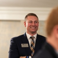 Kyle Herm from University Development standing with his arms crossed smiling